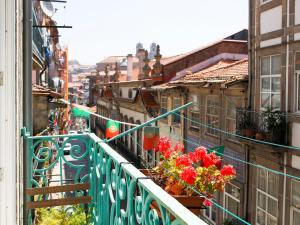 a balcony with red flowers on a building at OX Apartments B Places in Porto