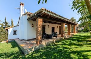 a guest house with a patio in a yard at Hacienda Roche Viejo in Conil de la Frontera