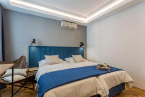 a bedroom with a large bed with a blue headboard at Central Rooms Split in Split