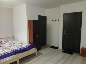 een slaapkamer met een bed en twee bruine kasten bij Oaza Kaszubska Studzienice in Studzienice