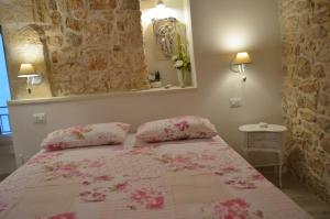 コンヴェルサーノにあるB&B Cieli di Danteのベッドルーム1室(ピンクのシーツと枕のベッド1台付)