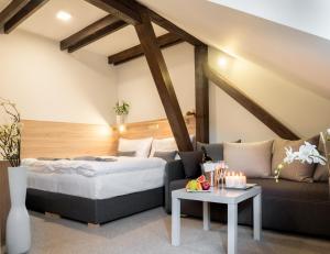 ein Schlafzimmer mit einem Bett, einem Sofa und einem Tisch in der Unterkunft Club Apartments in Čeladná