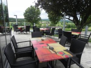 d'une terrasse avec des tables, des chaises et une table avec des outils. dans l'établissement Hotel - Restaurant Uit De Kunst, à Vijlen