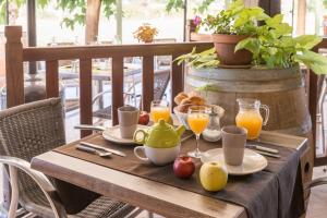 a wooden table with breakfast foods and drinks on it at Logis Hôtel Les 3B in Nouilhan