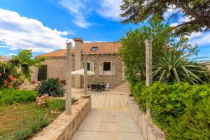 a stone house with a pathway leading to a yard at Hedera Estate, House Hedera V in Dubrovnik