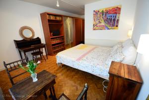 a bedroom with a bed and a desk and a piano at La Victoire de Noyers in Noyers-sur-Serein