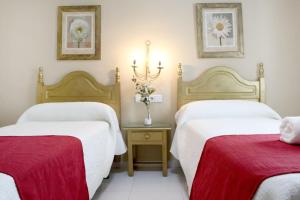 Postel nebo postele na pokoji v ubytování Hostal Victoria