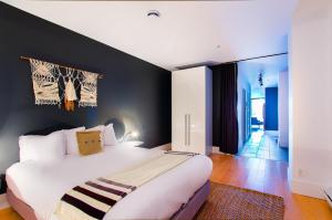 a bedroom with a large white bed and a black wall at Les Lofts St-Joseph - Par Les Lofts Vieux-Québec in Quebec City