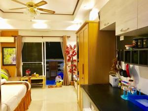 a bedroom with a bed and a kitchen with a counter at Rayong Condochain by Rainbow in Ban Phe