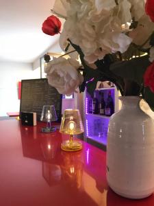 a vase with flowers on a table with two candles at The Originals City, Hôtel Dau Ly, Lyon Est in Bron