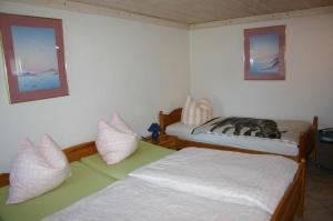 1 dormitorio con 2 camas y almohadas en Boddenbrise, en Born