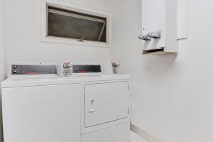 a white kitchen with a dishwasher and a window at Travel Inn in Horseheads