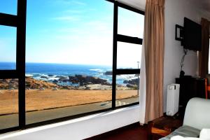 a room with a large window with a view of the ocean at Abalone Self-Catering in Lambertʼs Bay