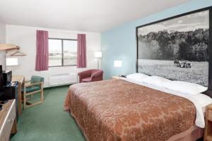 A bed or beds in a room at Super 8 by Wyndham Gas City Marion Area