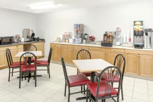 a restaurant with tables and chairs and a counter at Super 8 by Wyndham Gas City Marion Area in Gas City