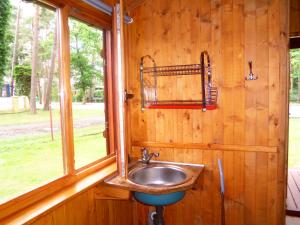 a sink in a wooden wall with a window at Domki Letniskowe Kaprys in Pobierowo +24 photos