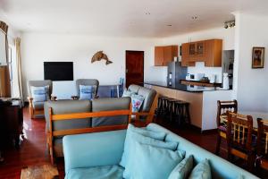 a living room with a couch and a kitchen at Abalone Self-Catering in Lambertʼs Bay