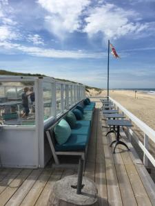 eine Reihe von Bänken am Strand in der Unterkunft Strandleven in Groote Keeten