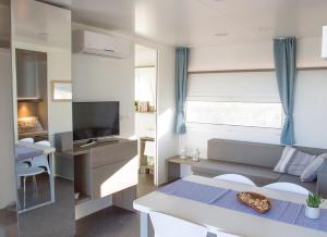 a living room with a couch and a tv at Adrijela Mobile Home in Jezera