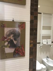 a bathroom with a picture of a woman on the wall at Aquila house in Catania
