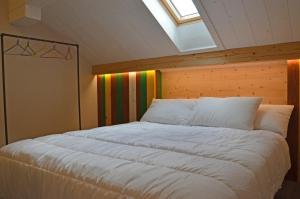 ピエーヴェ・ディ・カドーレにあるB&B Vicolo15の窓付きの客室で、白い大型ベッド1台が備わります。