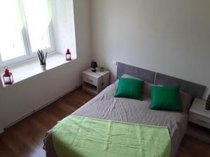 a bedroom with a bed with two green pillows at la grange de loghju in Villefort