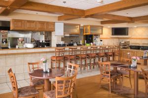 a restaurant with tables and chairs and a kitchen at The Carlton Lodge in Adrian