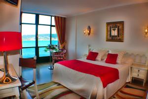 a bedroom with a large bed with a red blanket at Hotel Stellamaris in Combarro