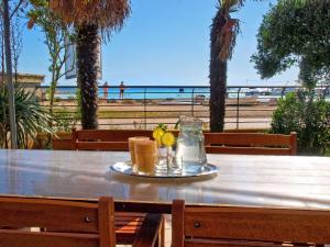 a table with two drinks on it with the beach at Apartments Volf 1405 in Peroj