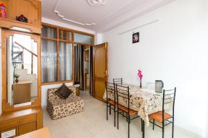 a dining room with a table and chairs in a room at The Thistle Lodge in Shimla