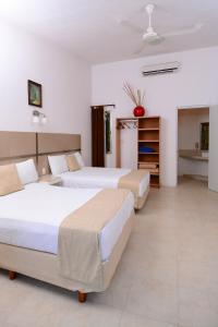 a hotel room with two beds and a kitchen at Hotel Villas Bambu in Chetumal