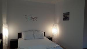 ママイアにあるStudio Adinaのベッドルーム1室(白いベッド1台、照明2つ付)