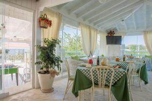 a dining room with green tables and chairs and windows at Agriturismo Salinola in Ostuni