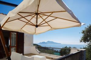 un grande ombrellone abbronzante su un balcone con vista sull'oceano di Il Nido del Gabbiano a Massa Lubrense