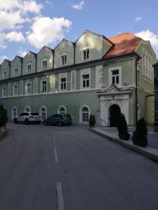 a large building with cars parked in a parking lot at Vila Park in Rogaška Slatina