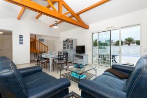 a living room with two blue couches and a table at Madame Vacances Le Domaine de Vertmarines in Saint-Jean-de-Monts