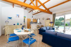 eine Küche und ein Wohnzimmer mit einem Tisch und Stühlen in der Unterkunft Madame Vacances Le Domaine de Vertmarines in Saint-Jean-de-Monts