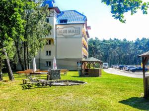 a building with a park with benches and a gazebo at Blue Mare Apartamenty U Tomka in Łukęcin