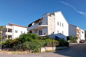 a white building with a fence in front of it at Anchor Apartments in Stari Grad