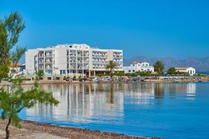 un gran edificio blanco junto a una masa de agua en Hotel Moré, en Alcudia