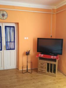 ein Wohnzimmer mit einem Flachbild-TV an der Wand in der Unterkunft Edit Vendégház in Tiszaújváros