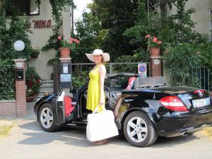 a woman in a yellow dress standing next to a car at B&B da NINA in Sabbioneta