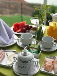 a table with plates of food and cups and fruit at Hotel Senac Ilha do Boi in Vitória