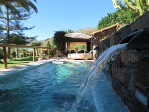 una piscina con cascata in un cortile di Villa Ayagaures a Los Palmitos