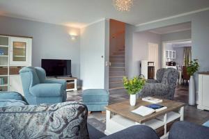 a living room with blue chairs and a table at Villa Emma in Ostseebad Sellin