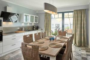uma cozinha com uma mesa de madeira e cadeiras numa cozinha em Villa Emma em Ostseebad Sellin