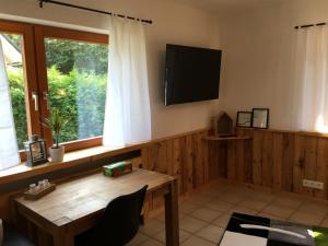 a living room with a wooden table and a television at Deine-Ferienwohnung in Mahlberg