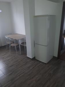 a dining room with a table and a refrigerator at Apartament Faleza Dunării in Orşova