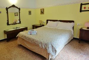 a bedroom with a large bed and a mirror at La casa di Nonna Nilla in San Giovanni Bianco