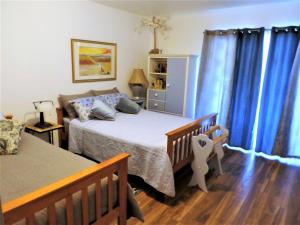 a bedroom with two beds and blue curtains at NEW CHARMING 2 BEDROOMS UNIT CLOSE TO EVERYTHING in Oakhurst